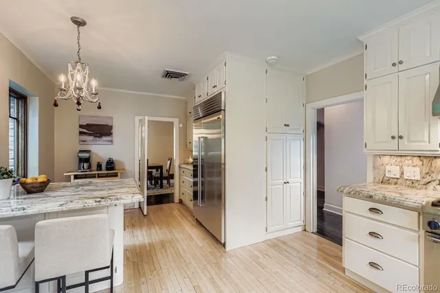 a view of kitchen with granite countertop cabinets and refrigerator