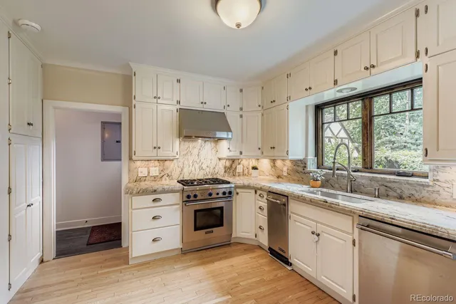 a kitchen with stainless steel appliances a stove a sink and a refrigerator