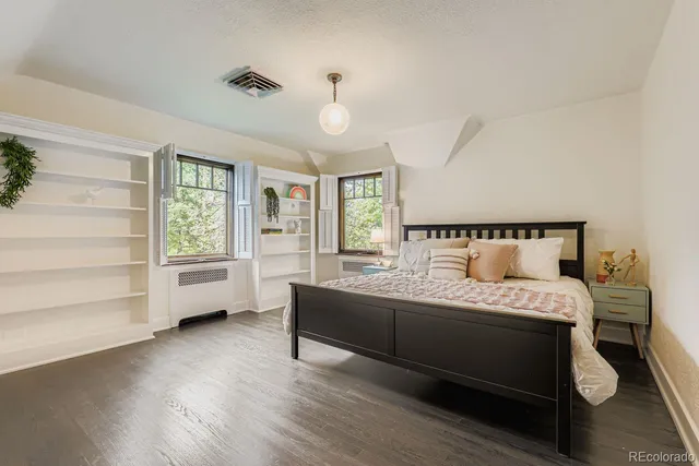 a bedroom with a bed wooden floor and window
