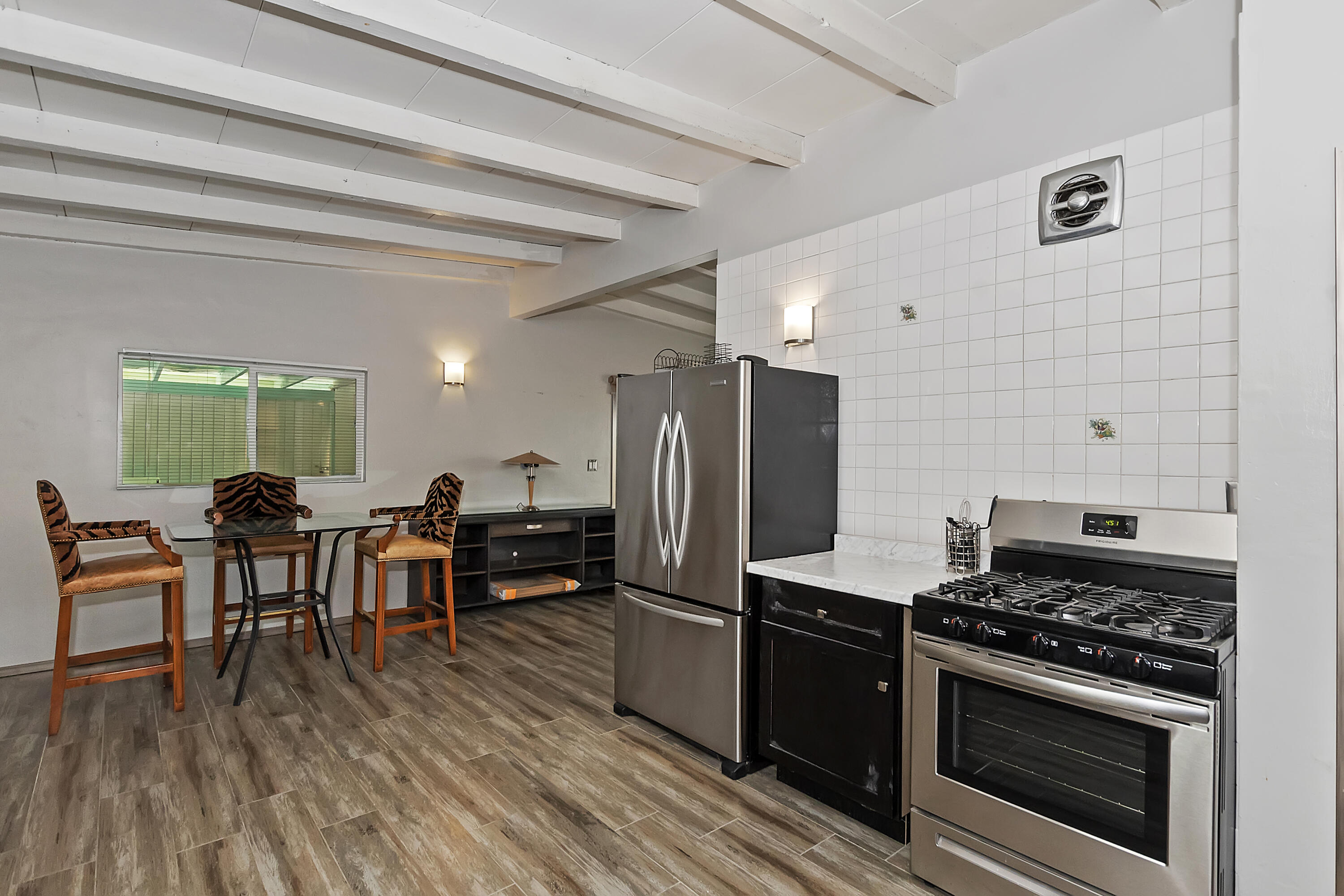 38957 Miller Lane Cathedral City, CA 92234 - Photo 16 of 34 a kitchen with stainless steel appliances wooden floor dining table and chairs