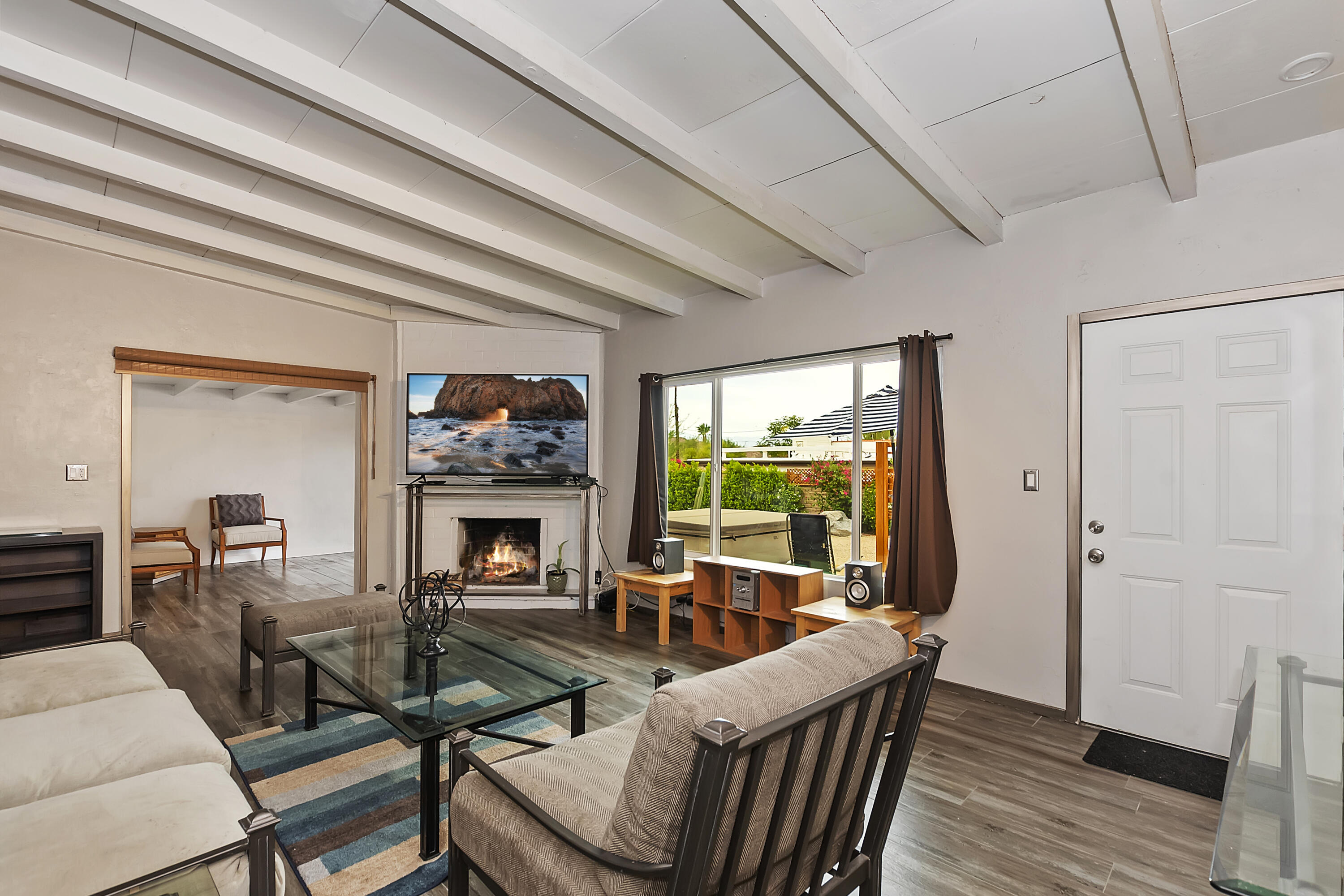 38957 Miller Lane Cathedral City, CA 92234 - Photo 7 of 34 a living room with furniture a fireplace and a floor to ceiling window