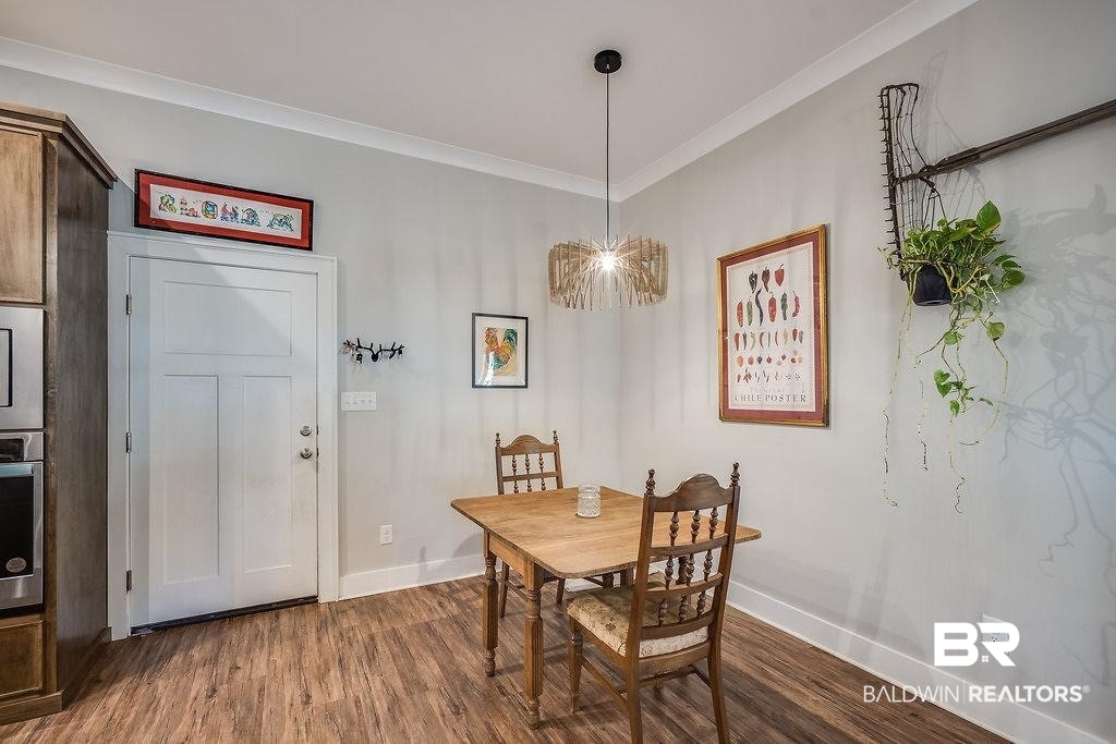 7420 Pake Road Saraland, AL 36571 - Photo 12 of 35 Dining space with dark wood-style flooring, ornamental molding, and baseboards