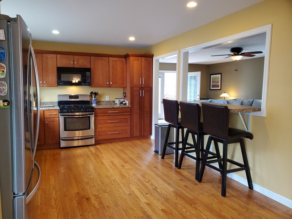 61 Windemere Street Springfield, MA 01104 - Photo 13 of 42 a kitchen with stainless steel appliances a table chairs and a refrigerator