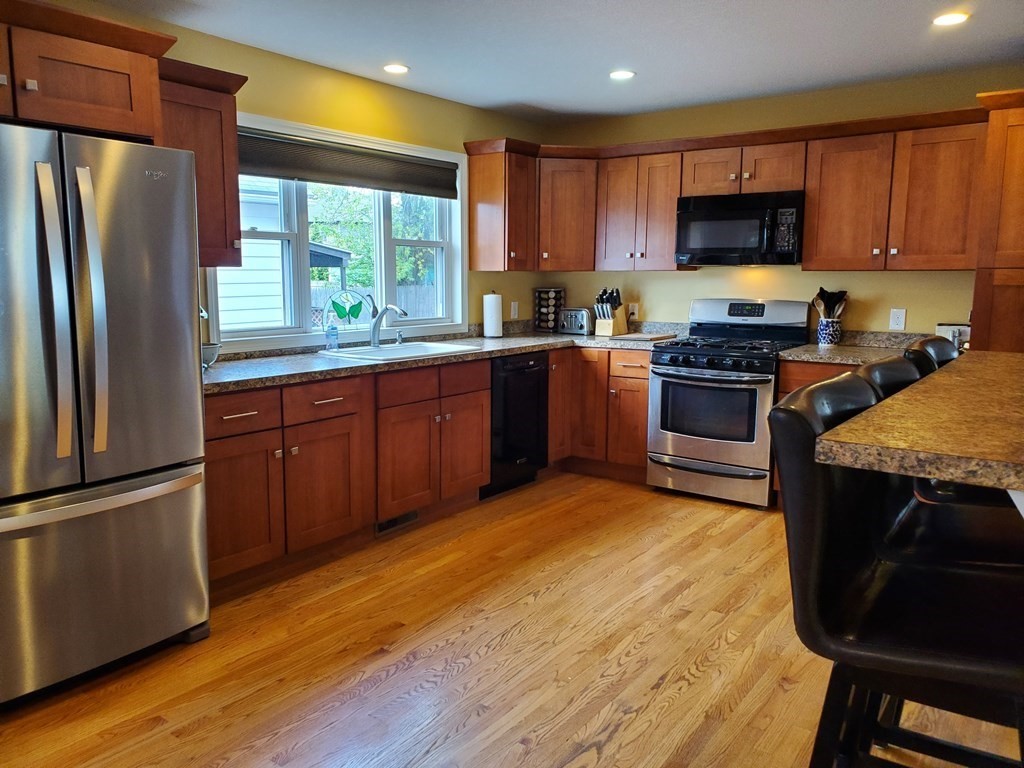 61 Windemere Street Springfield, MA 01104 - Photo 14 of 42 a kitchen with stainless steel appliances granite countertop a stove top oven a sink and a refrigerator