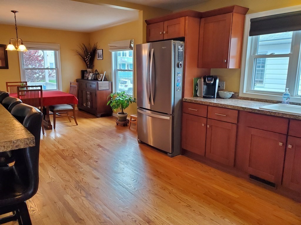 61 Windemere Street Springfield, MA 01104 - Photo 15 of 42 a kitchen with stainless steel appliances granite countertop a refrigerator a sink dishwasher a stove a dining table and chairs with wooden floor
