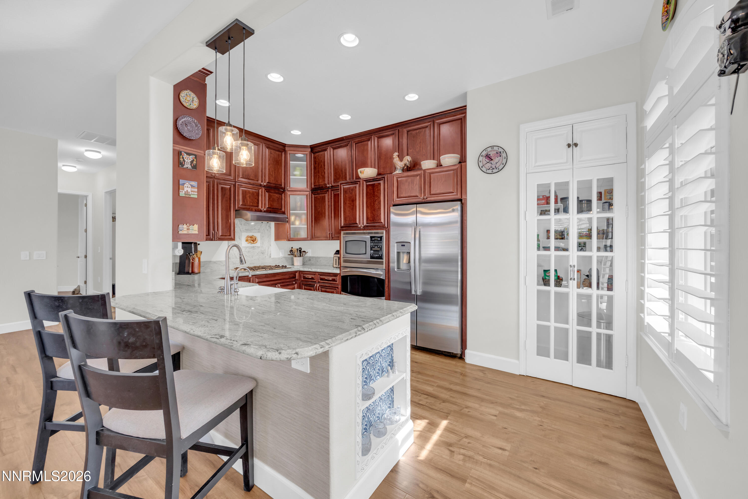 9900 Wilbur May Parkway, Unit 3903 Reno, NV 89521 - Photo 6 of 37 a kitchen with stainless steel appliances kitchen island granite countertop a refrigerator and a stove top oven