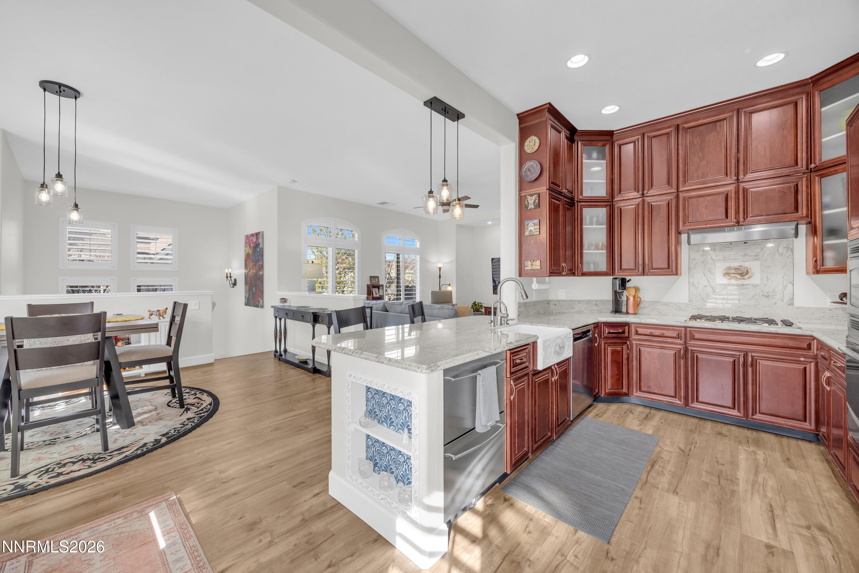 9900 Wilbur May Parkway, Unit 3903 Reno, NV 89521 - Photo 7 of 37 a large kitchen with stainless steel appliances kitchen island granite countertop a large stove a sink dishwasher and white cabinets with wooden floor