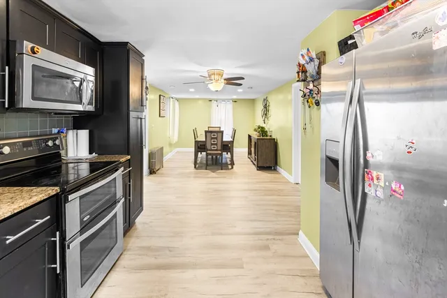 a kitchen with stainless steel appliances granite countertop a refrigerator a stove and a sink