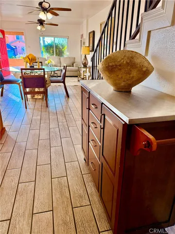 a living room with stainless steel appliances furniture a rug and a large window