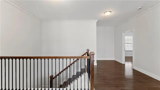 an empty room with wooden floor closet and windows