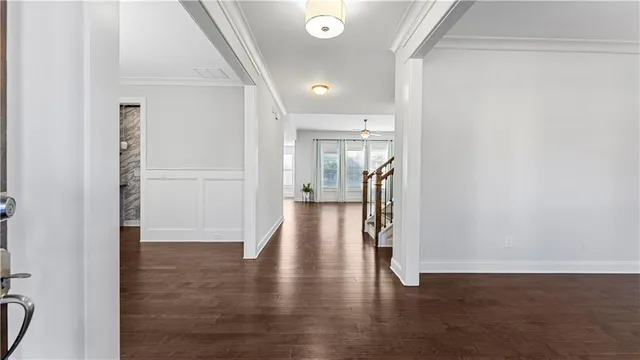 an empty room with wooden floor a ceiling fan and windows