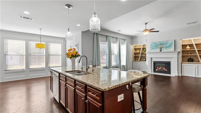 an empty room with wooden floor fireplace and windows