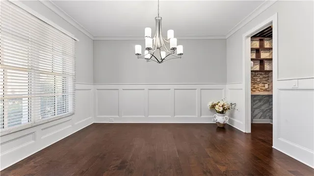 a view of a hallway with wooden floor and a chandelier