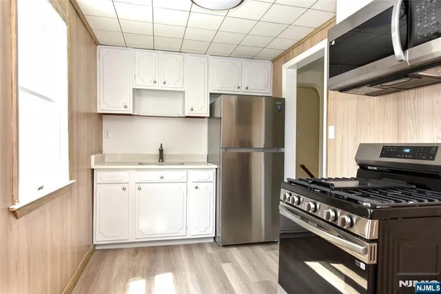 a kitchen with a refrigerator a stove a microwave and cabinets