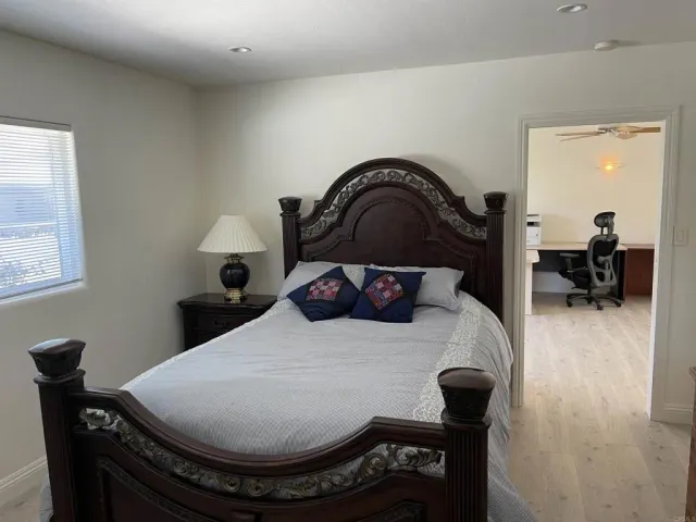 a bed sitting in a bedroom next to a window