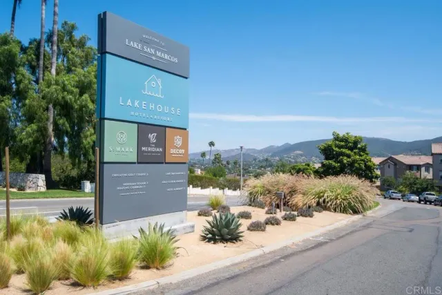 a view of a house with a yard and table and chairs under an umbrella