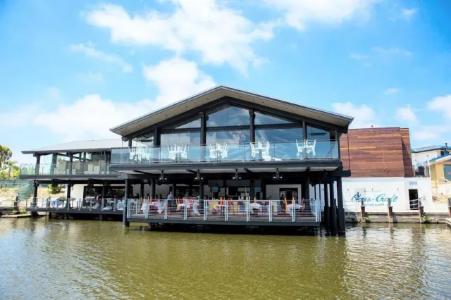 a view of a large pool with lawn chairs under an umbrella