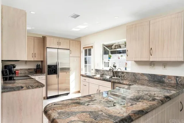 a kitchen with granite countertop sink and cabinets