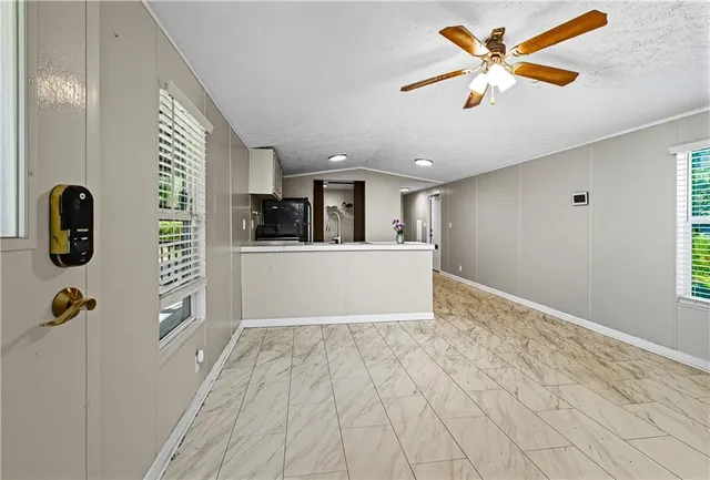 an empty room with fan and windows