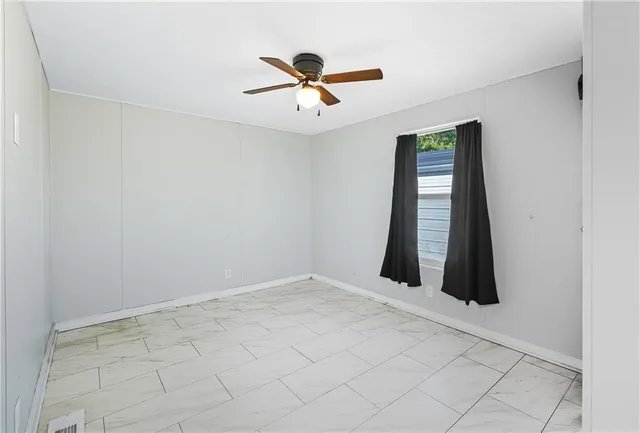 a view of a kitchen with refrigerator and white cabinets