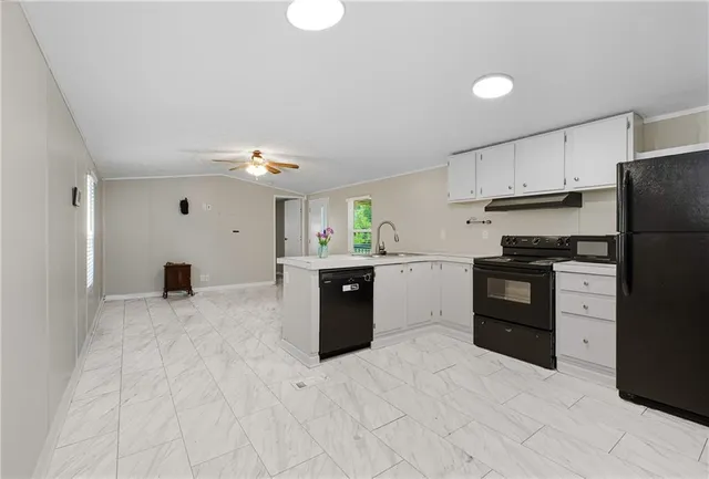 a kitchen with granite countertop a sink stove and refrigerator