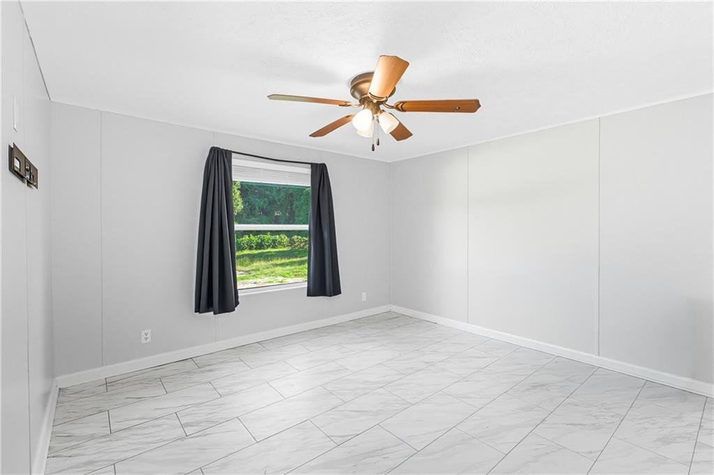 221 McAllister Road Cornelia, GA 30531 - Photo 23 of 58 a view of an empty room with window and chandelier fan