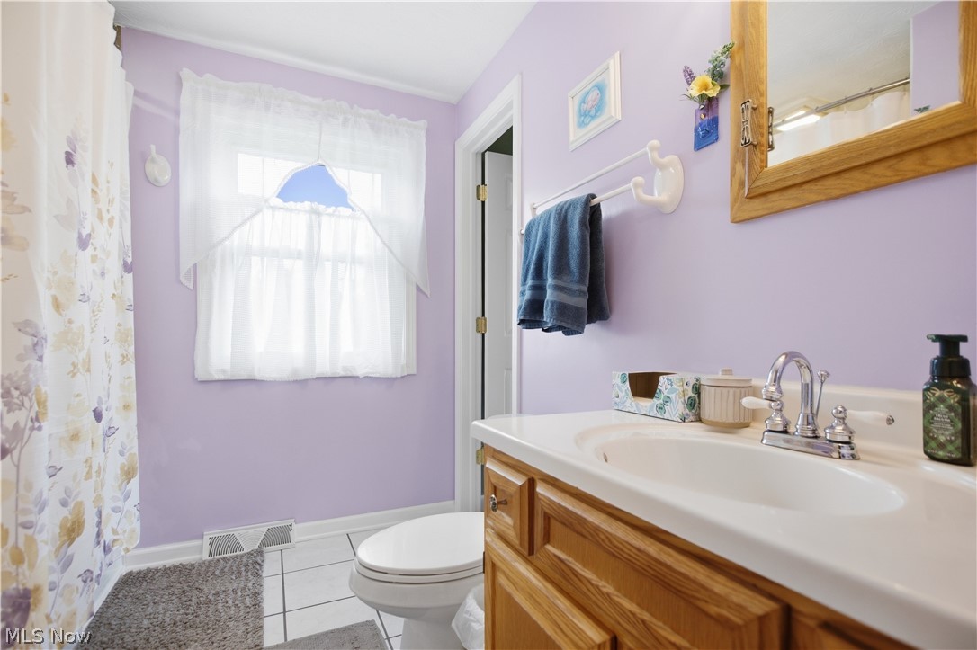 5972 Keller Road Akron, OH 44319 - Photo 21 of 29 Bathroom featuring a window, wood vanity with integrated sink, chrome faucet, and tile flooring
