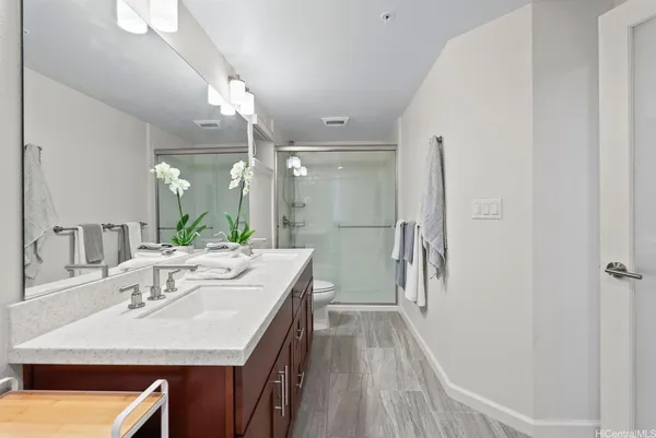 a bathroom with a sink a toilet a mirror and shower
