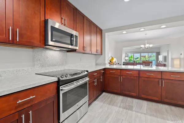 a kitchen with stainless steel appliances granite countertop wooden cabinets stove top oven and sink