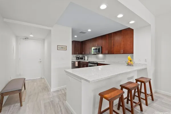 a kitchen with a table chairs refrigerator and wooden cabinets