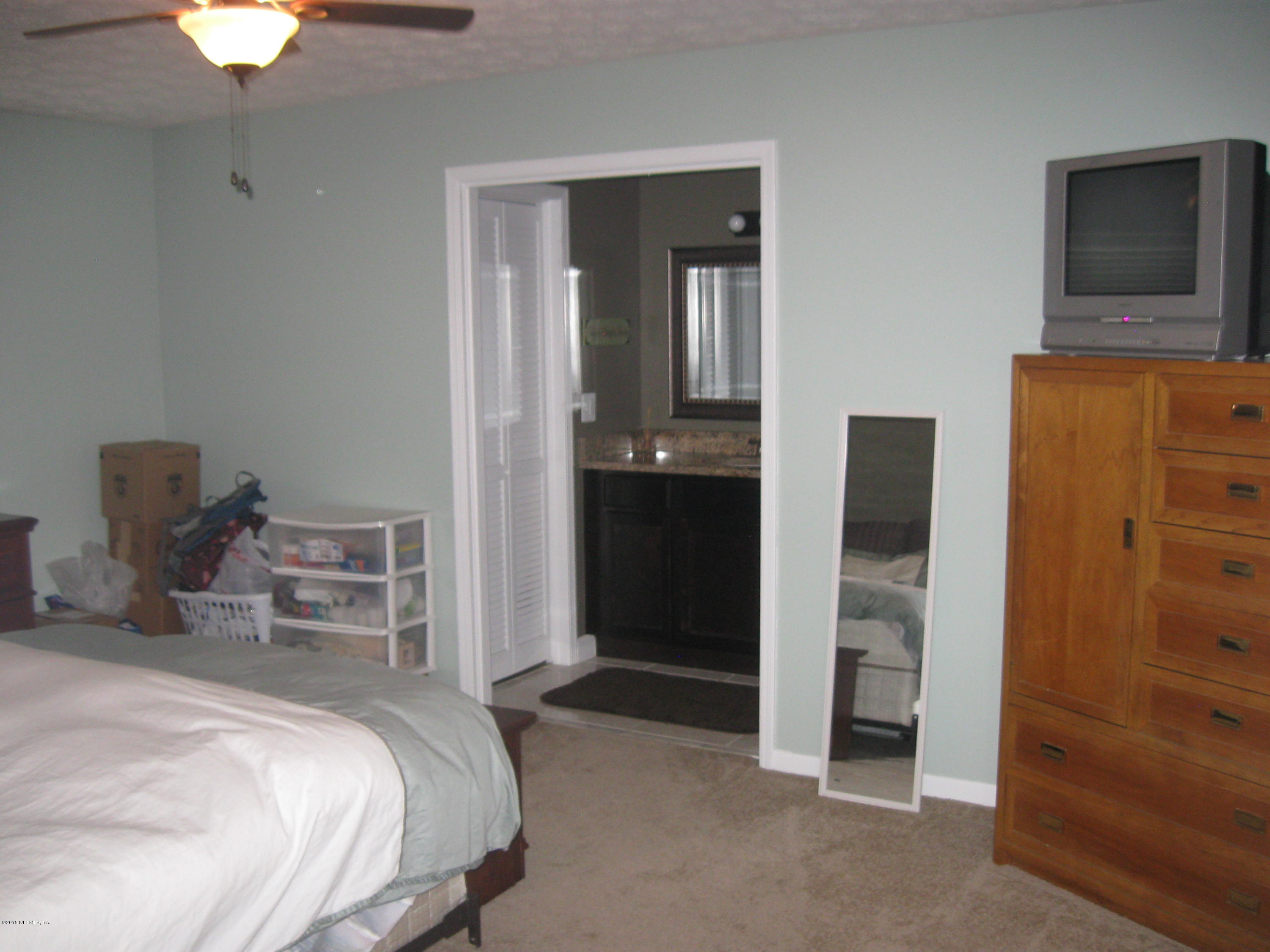 5535 Weaver Road Orange Park, FL 32073 - Photo 16 of 31 a bedroom with a bed and a chandelier