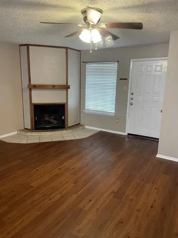 a view of a livingroom with wooden floor a fireplace and window
