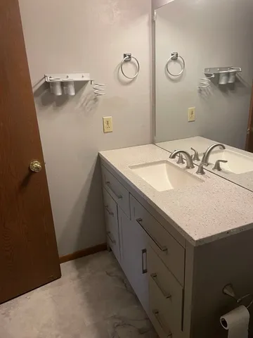a bathroom with a sink vanity and a mirror