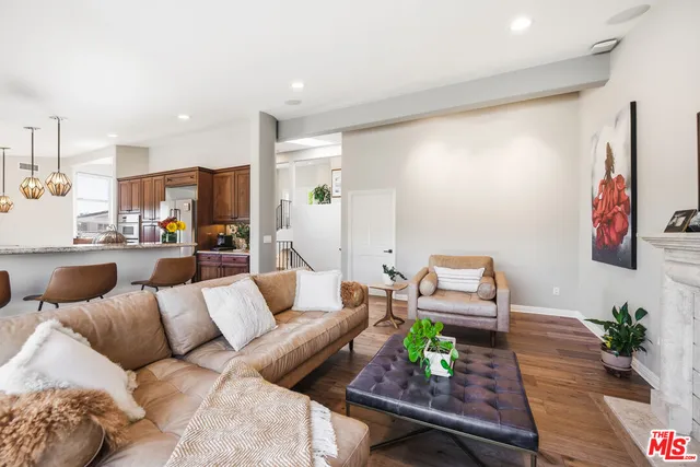 a living room with furniture kitchen view and a large window