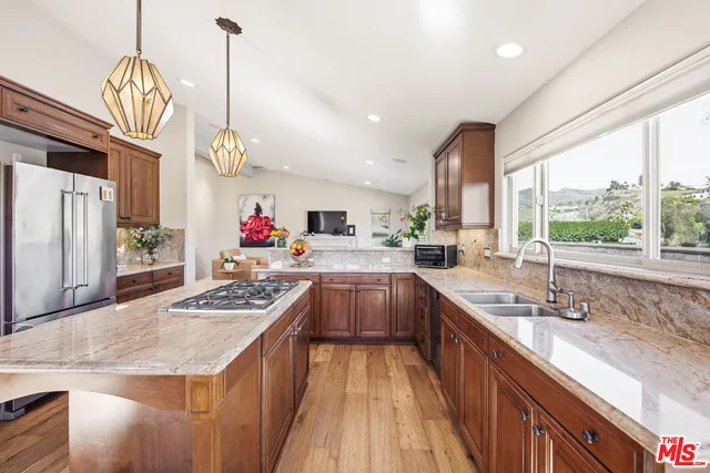 a kitchen with stainless steel appliances granite countertop a sink stove and refrigerator