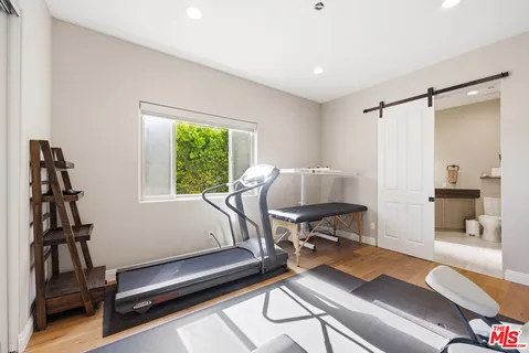 a living room with furniture gym equipment and a window
