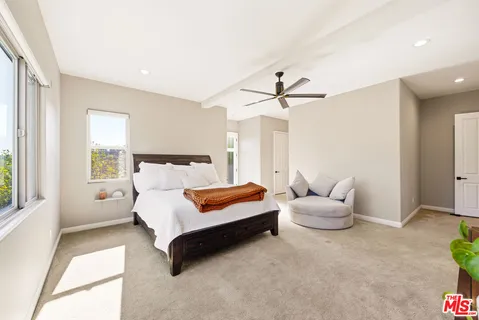 a spacious bedroom with a bed and a chandelier