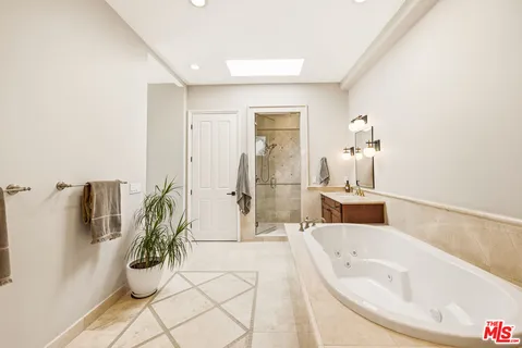 a spacious bathroom with a bathtub and potted plant