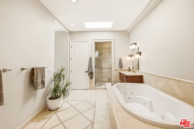 a spacious bathroom with a bathtub and potted plant