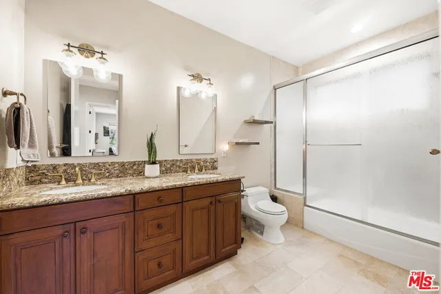 a bathroom with a double vanity sink toilet and shower