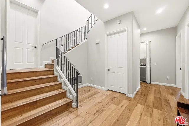 a view of a hallway with wooden floor and entryway