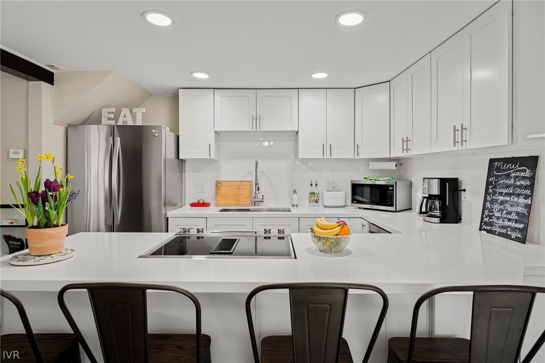 806 Oriole Way, Unit 16 Incline Village, NV 89451 - Photo 6 of 17 a kitchen with stainless steel appliances a dining table chairs refrigerator and microwave