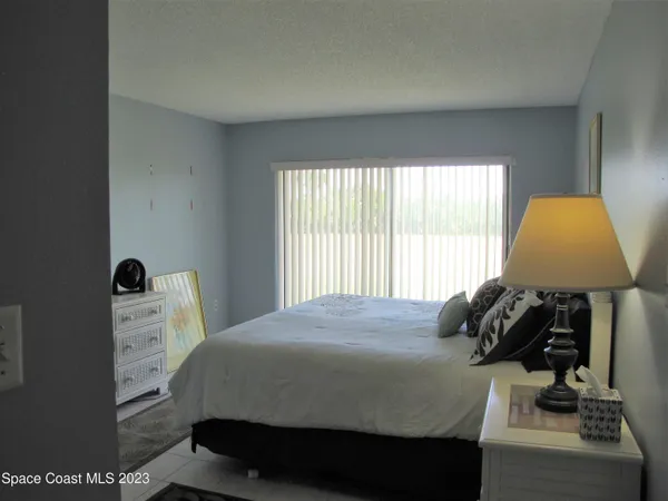 a bedroom with a bed a window and dresser