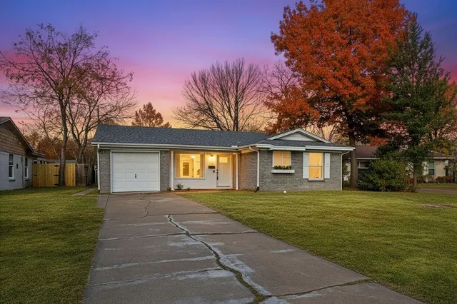 a front view of a house with a yard and trees