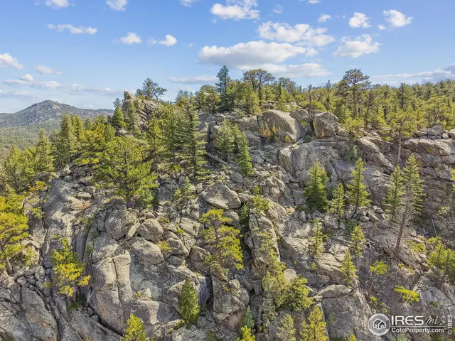 a view of a house with a wooden deck and trees