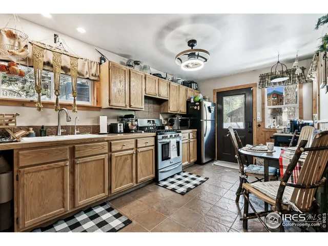 a kitchen with stainless steel appliances kitchen island granite countertop a sink cabinets and living room view