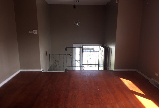 725 East 152nd Street Phoenix, IL 60426 - Photo 2 of 13 an empty room with wooden floor and windows