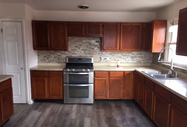 725 East 152nd Street Phoenix, IL 60426 - Photo 4 of 13 a kitchen with stainless steel appliances wooden cabinets and a stove top oven