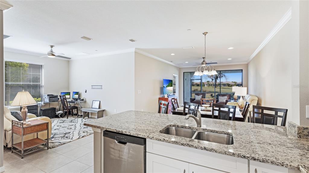 13719 Messina Loop, Unit 101 Lakewood Ranch, FL 34211 - Photo 11 of 77 a kitchen with a sink a counter and chairs