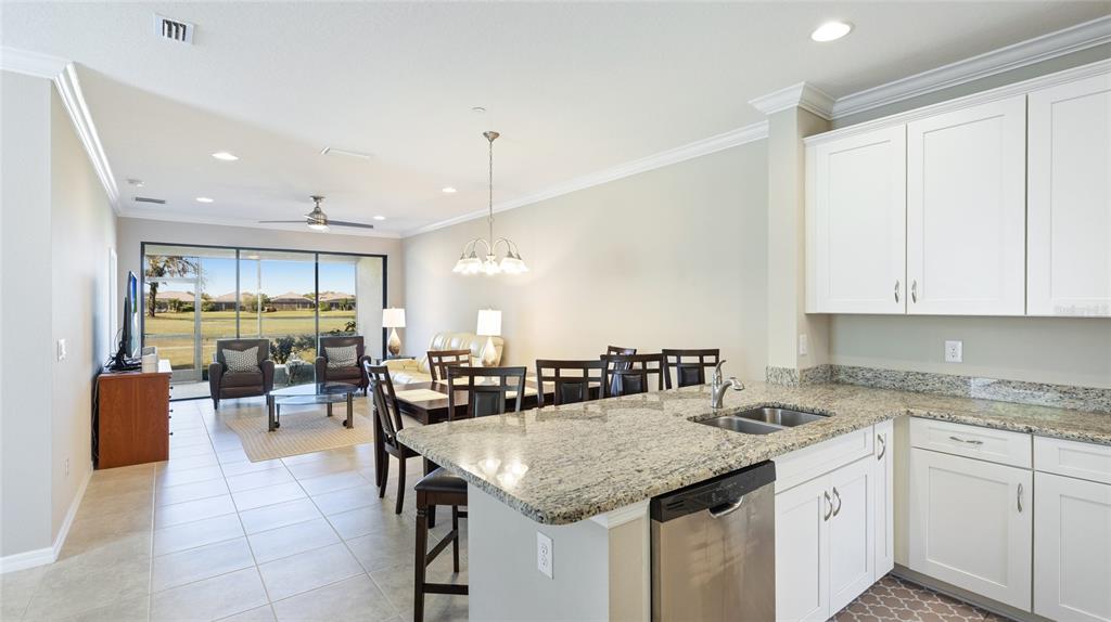 13719 Messina Loop, Unit 101 Lakewood Ranch, FL 34211 - Photo 13 of 77 a kitchen with granite countertop a sink a counter top space and living room view